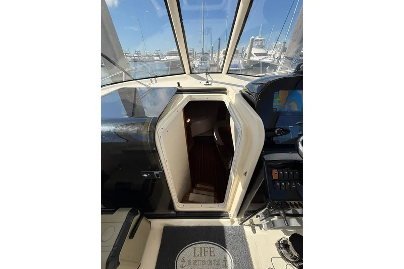  Yacht Photos Pics 2004 Pursuit 3370 Offshore boat interior with open cabin door, marina view.