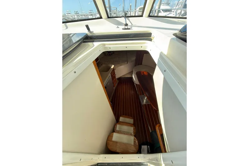  Yacht Photos Pics 2004 Pursuit 3370 Offshore cabin interior with wooden flooring and seating area.