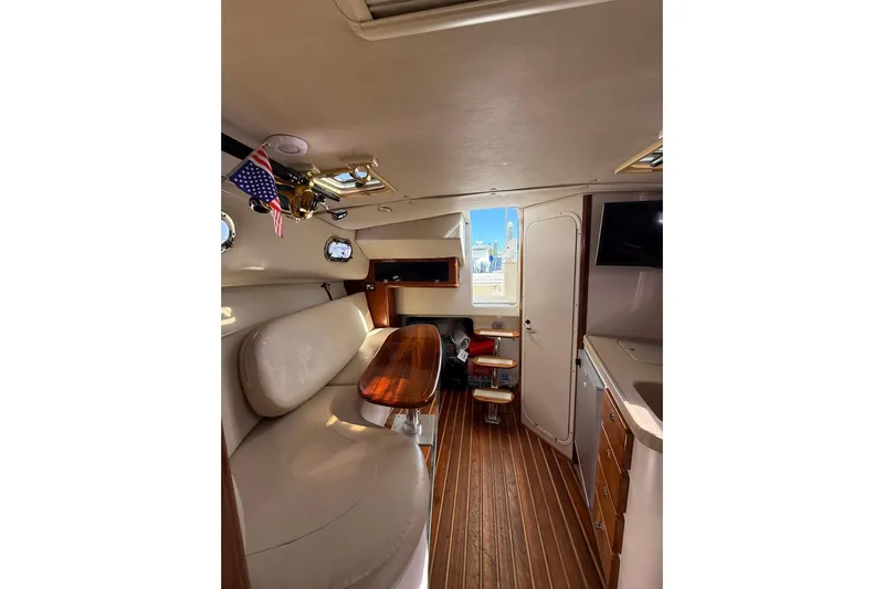  Yacht Photos Pics Interior of 2004 Pursuit 3370 Offshore boat with seating, table, and kitchenette.