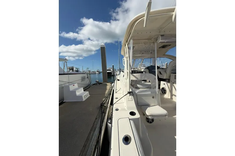  Yacht Photos Pics 2004 Pursuit 3370 Offshore boat docked at marina under blue sky.