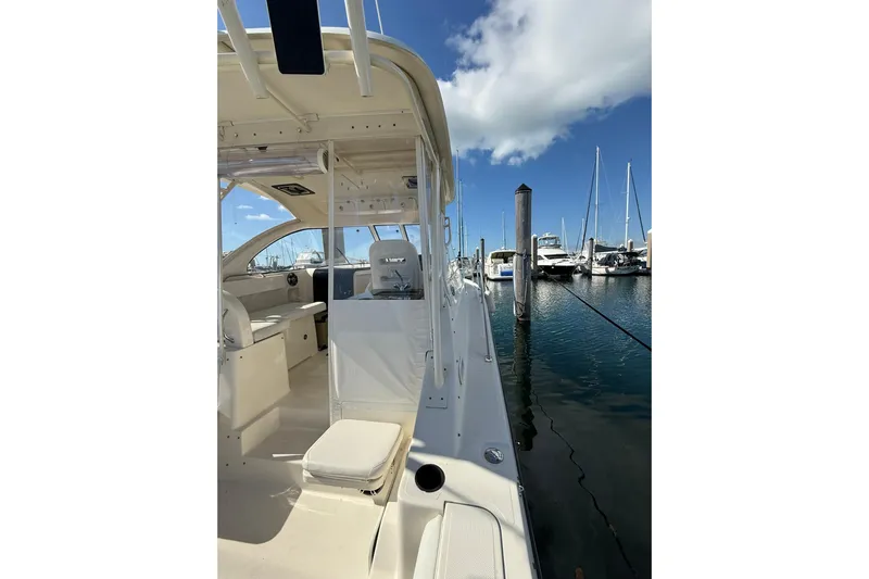  Yacht Photos Pics 2004 Pursuit 3370 Offshore boat docked at marina, clear sky, calm water.