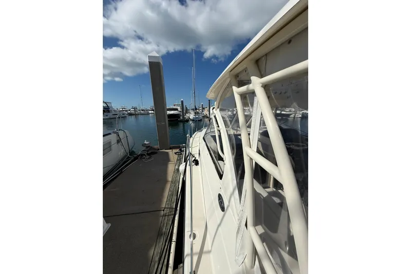  Yacht Photos Pics 2004 Pursuit 3370 Offshore boat docked at marina under blue sky.