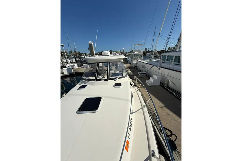  Yacht Photos Pics 2004 Pursuit 3370 Offshore boat docked at marina under clear blue sky.