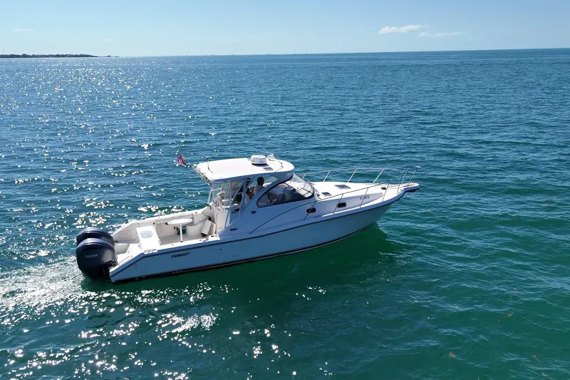  Yacht Photos Pics 2004 Pursuit 3370 Offshore boat cruising on clear blue ocean waters.