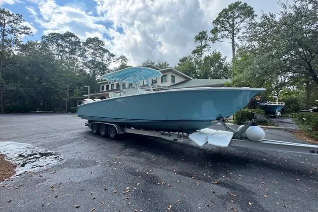  Yacht Photos Pics 2014 Jupiter 34 boat on trailer in a wooded residential area.