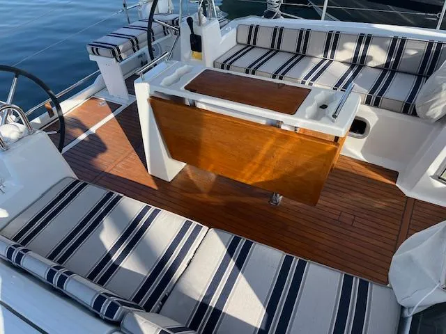 Nansea I Yacht Photos Pics Beneteau Oceanis 38.1 cockpit with striped cushions and wooden table, 2017 model.