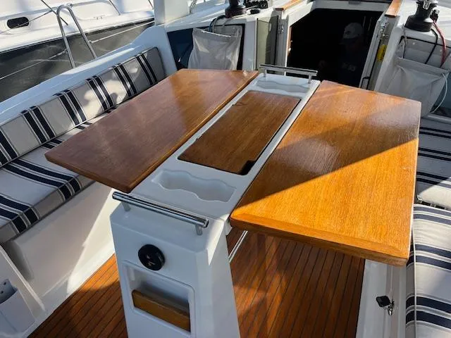 Nansea I Yacht Photos Pics Cockpit of 2017 Beneteau Oceanis 38.1 with wooden table and striped seating.