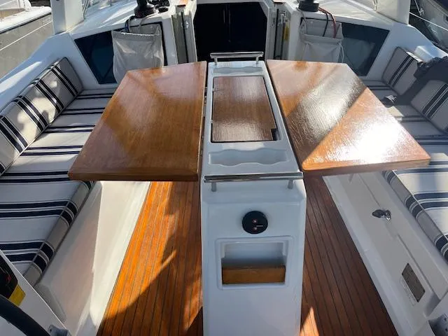Nansea I Yacht Photos Pics 2017 Beneteau Oceanis 38.1 cockpit with wooden table and striped seating.