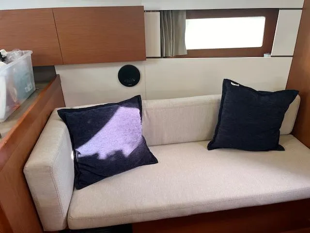 Nansea I Yacht Photos Pics Interior of 2017 Beneteau Oceanis 38.1 yacht with beige sofa and navy cushions.