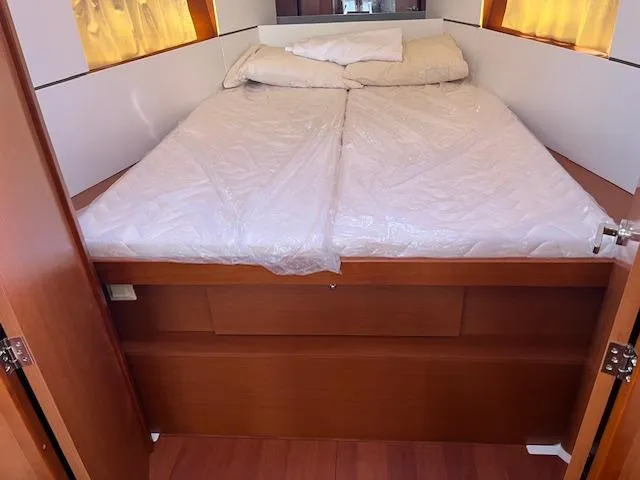 Nansea I Yacht Photos Pics Cabin bed in 2017 Beneteau Oceanis 38.1 yacht, featuring wooden finish and cozy bedding.