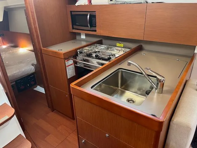 Nansea I Yacht Photos Pics 2017 Beneteau Oceanis 38.1 yacht kitchen with sink, stove, and microwave.