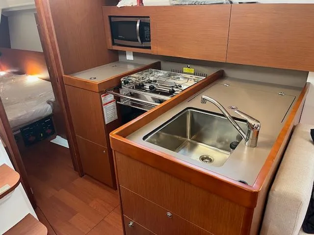 Nansea I Yacht Photos Pics 2017 Beneteau Oceanis 38.1 yacht kitchen with sink, stove, and microwave.