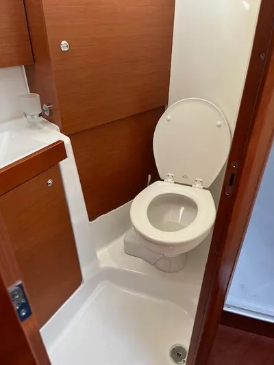 Nansea I Yacht Photos Pics 2017 Beneteau Oceanis 38.1 yacht bathroom with wooden cabinetry and white toilet.