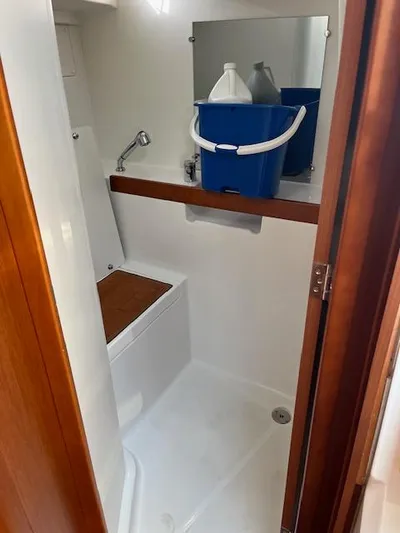 Nansea I Yacht Photos Pics Beneteau Oceanis 38.1 2017 bathroom with shower, wooden accents, and storage shelf.