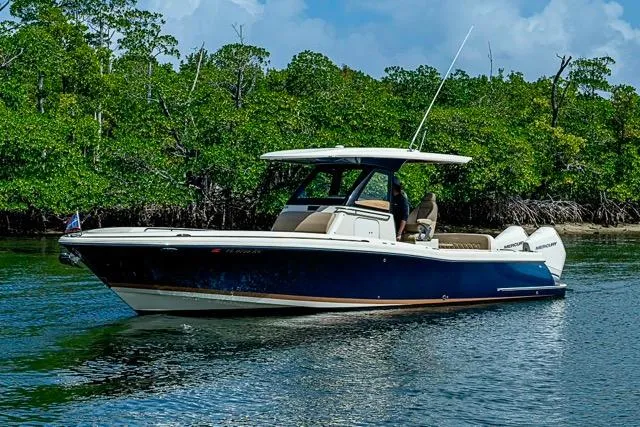  Yacht Photos Pics 2019 Chris-Craft Catalina 30 boat on calm water, surrounded by lush greenery.