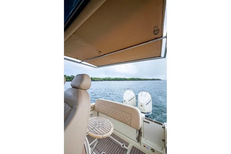  Yacht Photos Pics 2019 Chris-Craft Catalina 30 boat interior with canopy, seating, and twin outboard motors on water.