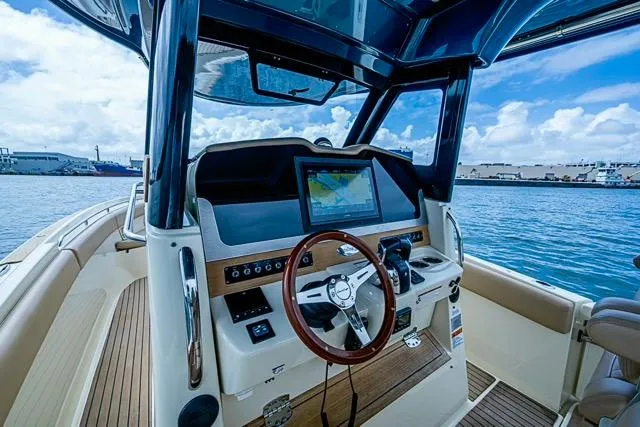  Yacht Photos Pics 2019 Chris-Craft Catalina 30 boat dashboard with navigation screen, steering wheel, and ocean view.