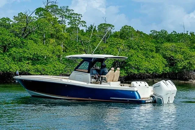  Yacht Photos Pics 2019 Chris-Craft Catalina 30 boat cruising near lush green shoreline.