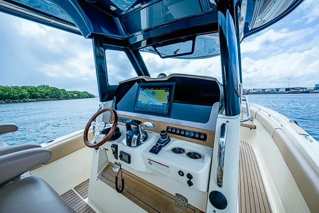  Yacht Photos Pics 2019 Chris-Craft Catalina 30 helm with navigation display, steering wheel, and controls on open water.