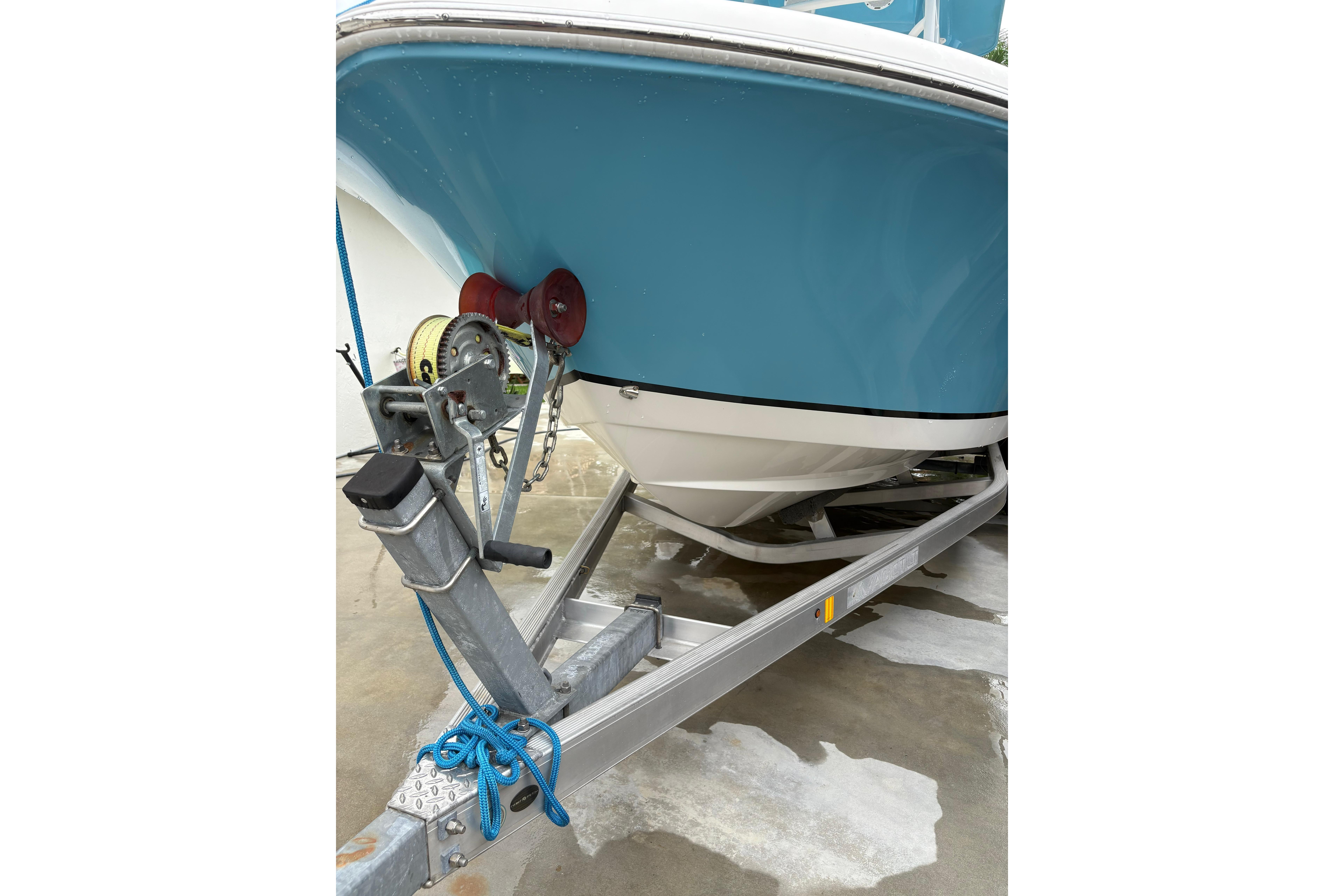 2019 Release 210 RX boat on trailer, blue hull, secured with winch and rope.