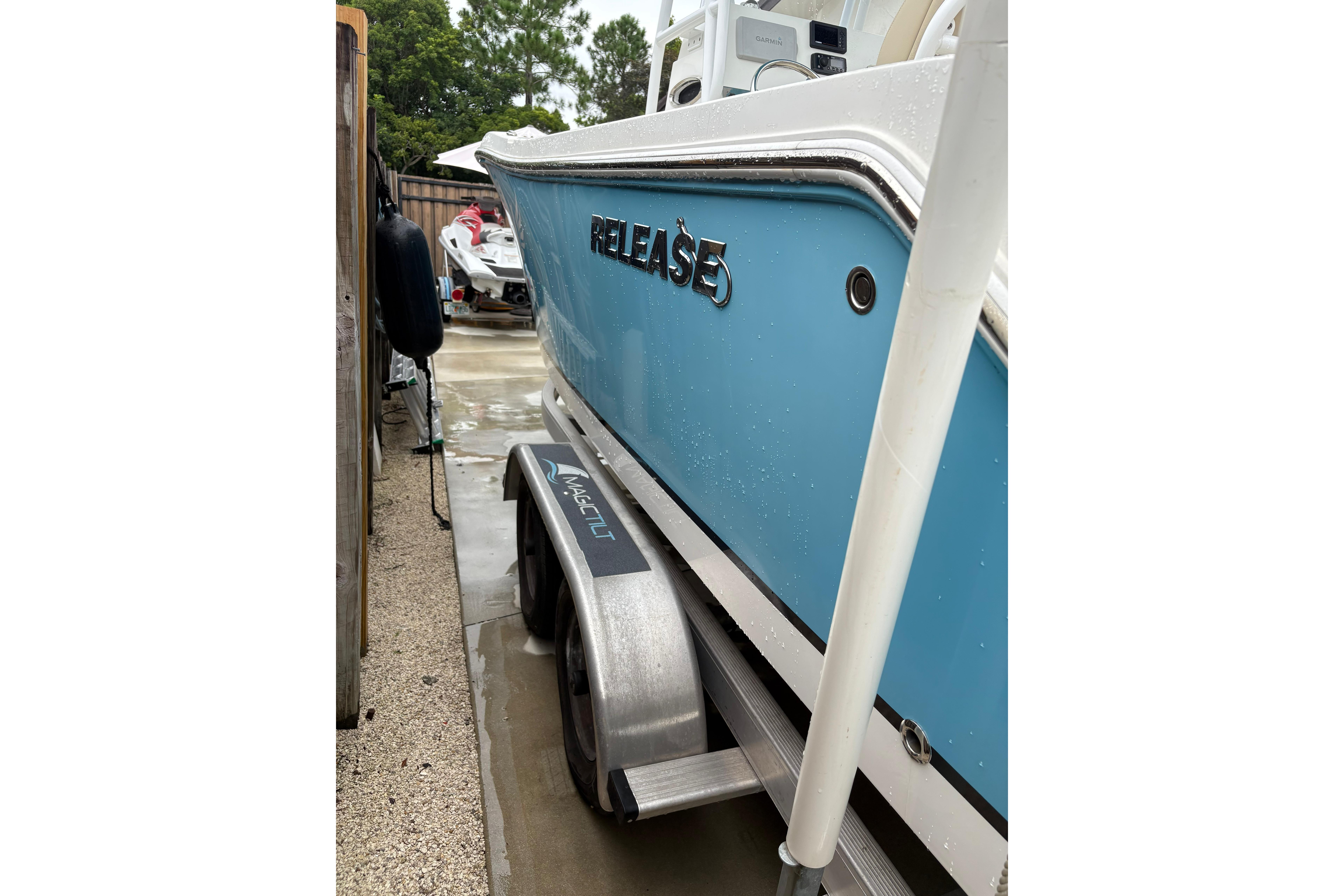 Blue 2019 Release 210 RX boat on trailer, parked outdoors.