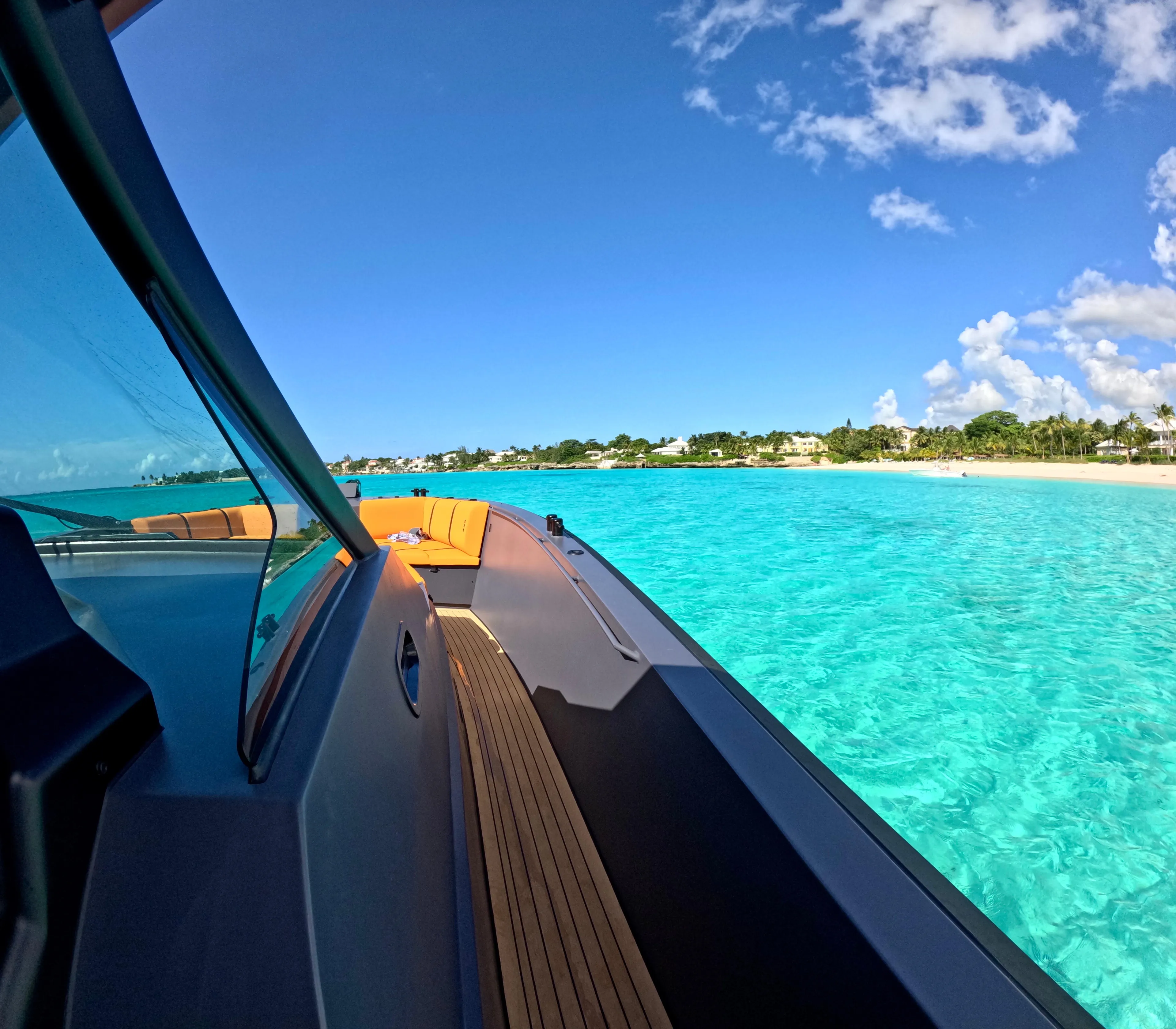  Yacht Photos Pics 2024 Lekker 44 yacht cruising in clear turquoise waters near a sandy beach.