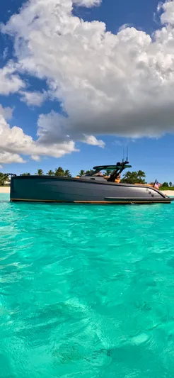  Yacht Photos Pics 2024 Lekker 44 yacht on turquoise water with palm trees and cloudy sky.