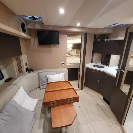  Yacht Photos Pics Interior of 2016 Cranchi Z35 yacht with cozy seating, table, and kitchenette.