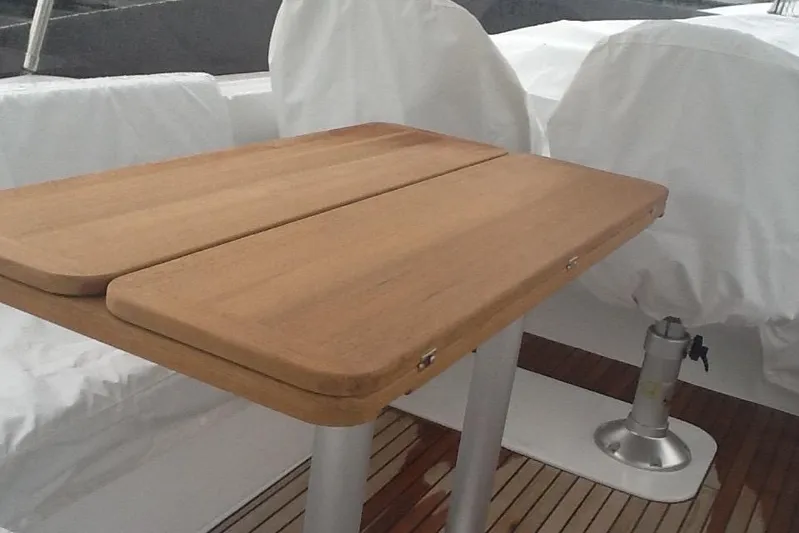  Yacht Photos Pics Wooden table on 2018 Beneteau Swift Trawler 50 deck, covered seating in background.