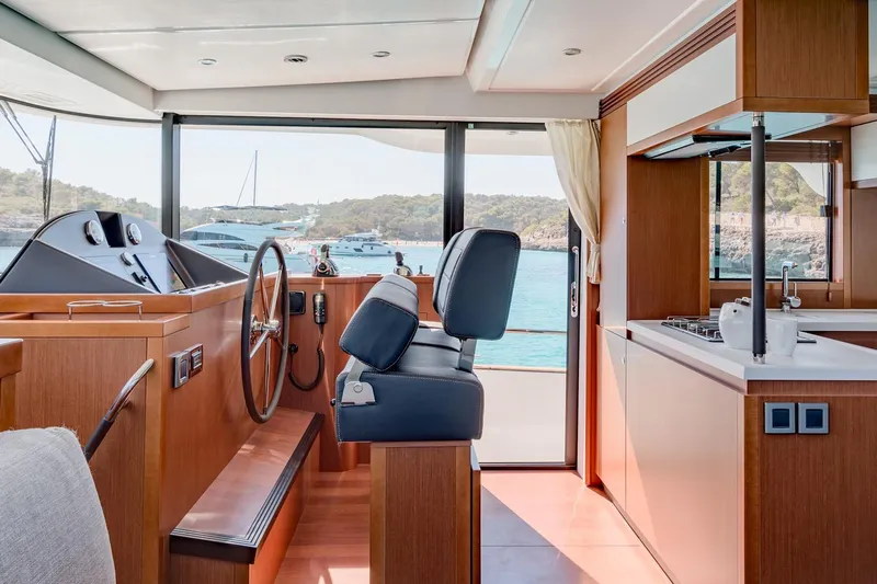  Yacht Photos Pics 2018 Beneteau Swift Trawler 50 interior with helm, kitchen, and scenic ocean view.