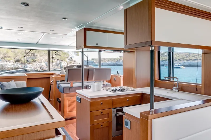  Yacht Photos Pics Luxurious interior of 2018 Beneteau Swift Trawler 50 with modern kitchen and scenic ocean view.