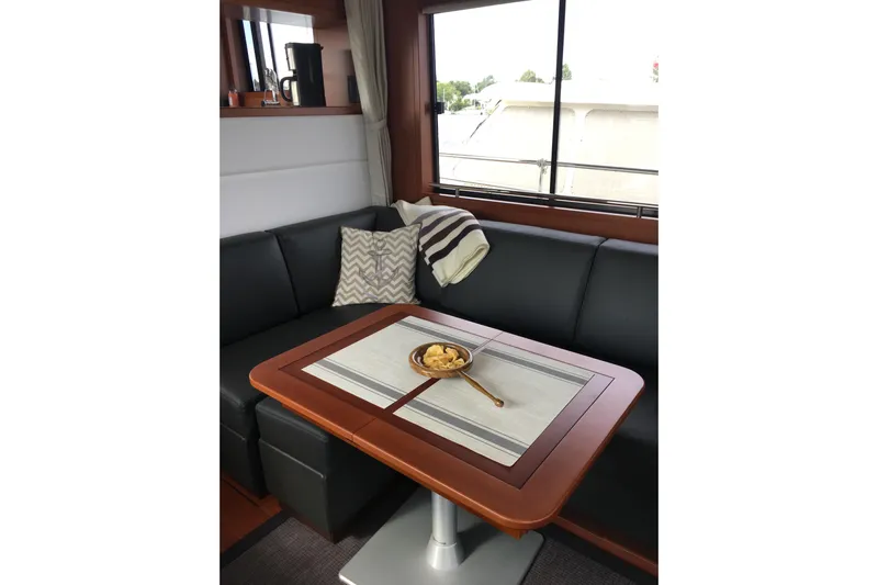 Yacht Photos Pics Interior of 2018 Beneteau Swift Trawler 50 with cozy seating and table setting.