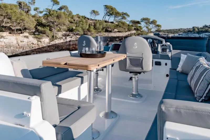  Yacht Photos Pics 2018 Beneteau Swift Trawler 50 deck with seating and table, scenic coastal view.