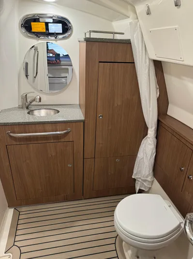  Yacht Photos Pics 2021 Boston Whaler 350 Outrage boat bathroom with wooden cabinetry and modern fixtures.