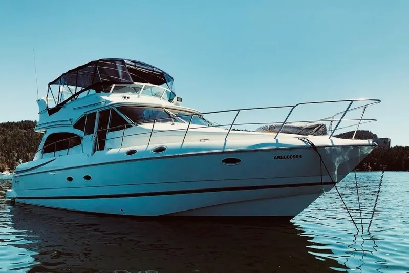  Yacht Photos Pics 2001 Cruisers Yachts 5000 Pilothouse on serene water, clear sky background.