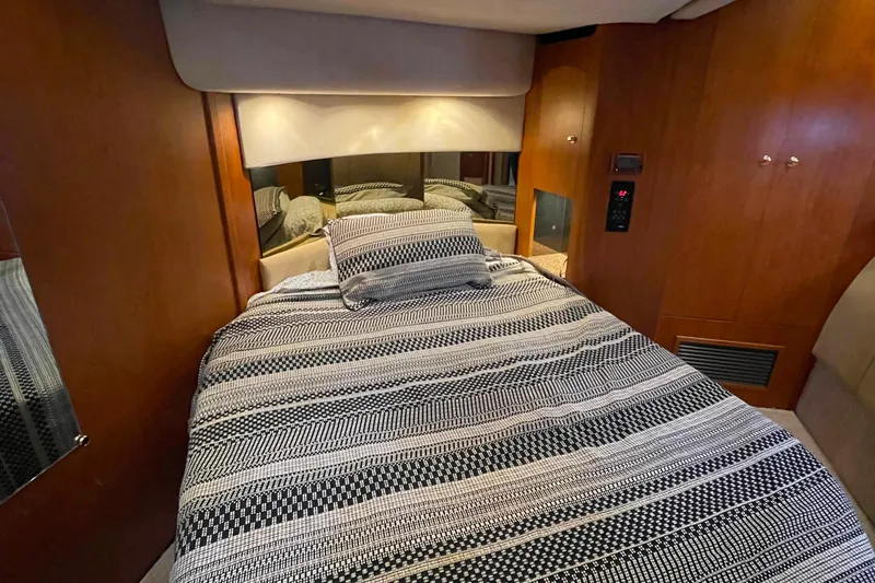  Yacht Photos Pics Interior cabin of 2001 Cruisers Yachts 5000 Pilothouse with cozy bed and wood paneling.