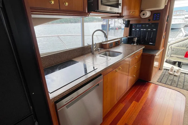  Yacht Photos Pics Luxurious 2001 Cruisers Yachts 5000 Pilothouse kitchen with modern appliances and scenic water view.
