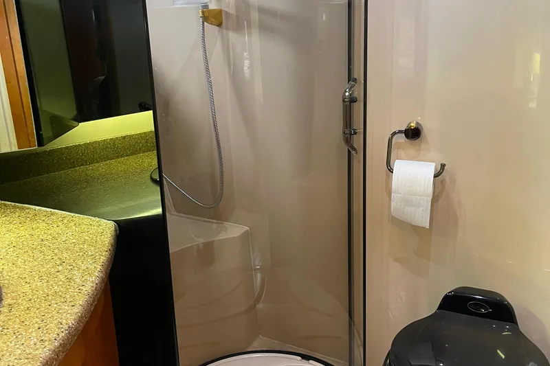  Yacht Photos Pics 2001 Cruisers Yachts 5000 Pilothouse bathroom with shower, toilet, and countertop.