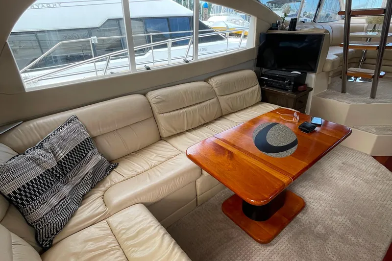  Yacht Photos Pics Luxurious interior of 2001 Cruisers Yachts 5000 Pilothouse with leather seating and wooden table.
