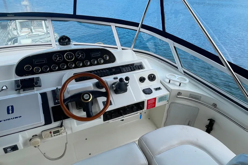  Yacht Photos Pics 2001 Cruisers Yachts 5000 Pilothouse helm with wooden steering wheel and ocean view.