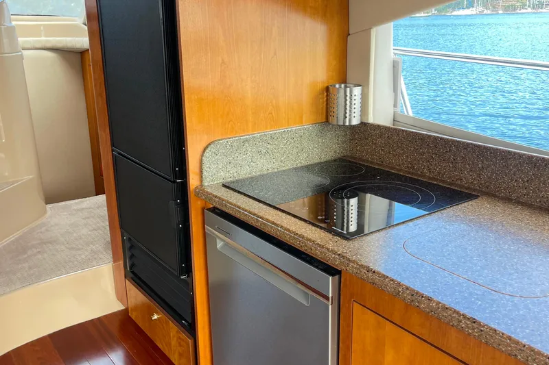  Yacht Photos Pics 2001 Cruisers Yachts 5000 Pilothouse kitchen with stove, fridge, and scenic water view.