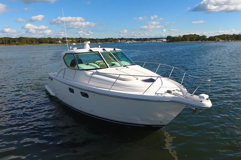 Ost - 39044 Yacht Photos Pics 2008 Tiara Yachts 3900 Sovran cruising on a serene lake under a blue sky.