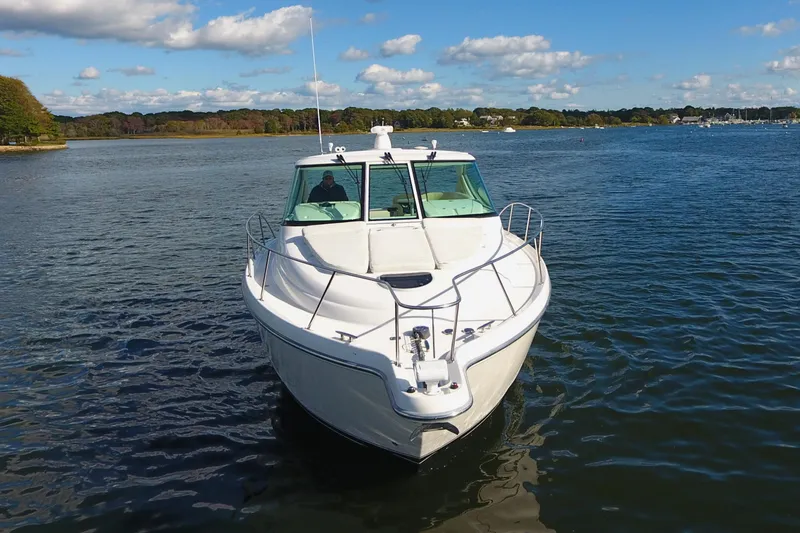 Ost - 39044 Yacht Photos Pics 2008 Tiara Yachts 3900 Sovran cruising on a serene lake under a blue sky.