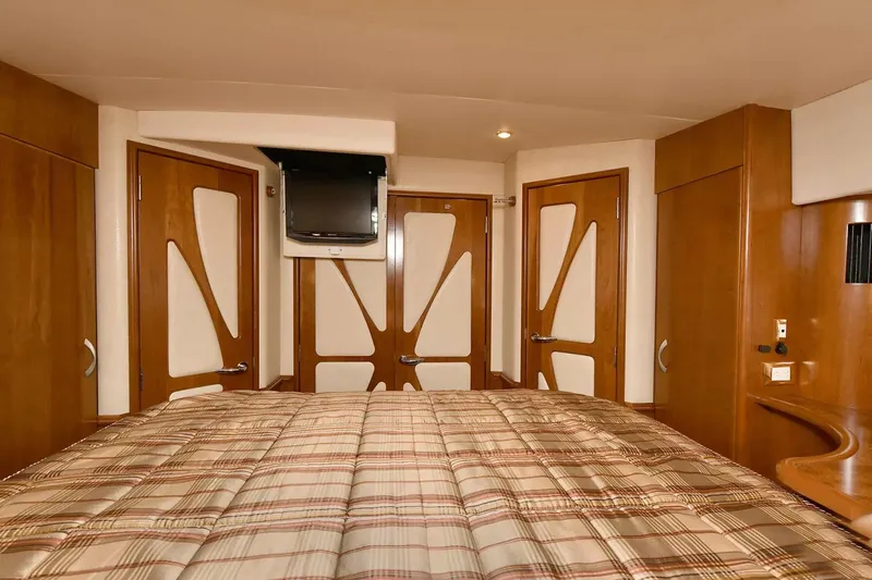 Chirstina Maria Yacht Photos Pics Luxurious bedroom interior of 2009 Silverton 52 Ovation yacht with modern wood paneling.