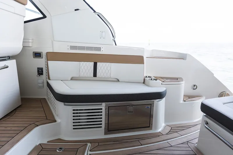  Yacht Photos Pics 2018 Sea Ray Sundancer 350 Coupe interior seating area with storage and wooden flooring.