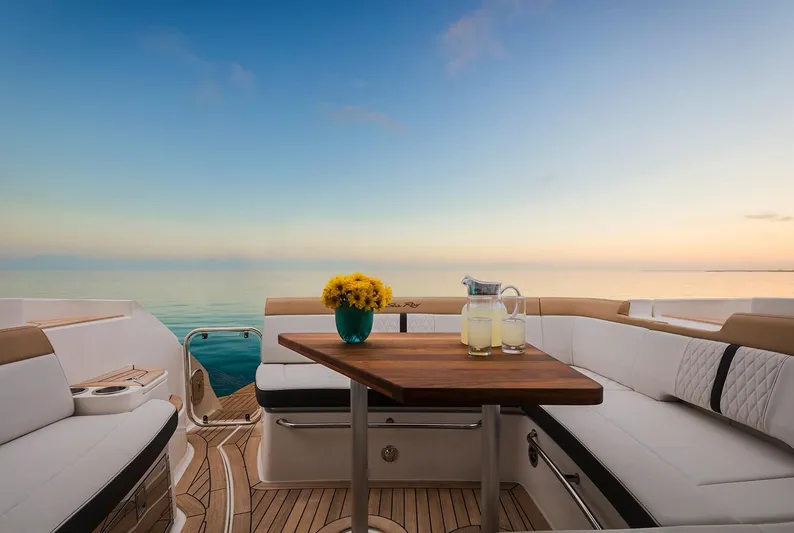  Yacht Photos Pics 2018 Sea Ray Sundancer 350 Coupe deck with ocean view, wooden table, and seating.