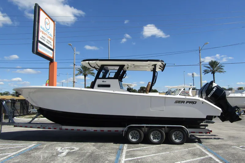  Yacht Photos Pics 2025 Sea Pro 322 Offshore boat on trailer at dealership under clear blue sky.