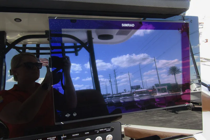  Yacht Photos Pics Simrad display on 2025 Sea Pro 322 Offshore boat, reflecting sky and surroundings.