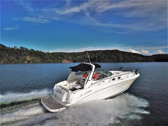  Yacht Photos Pics 2005 Sea Ray 360 Sundancer cruising on a scenic lake under a clear blue sky.