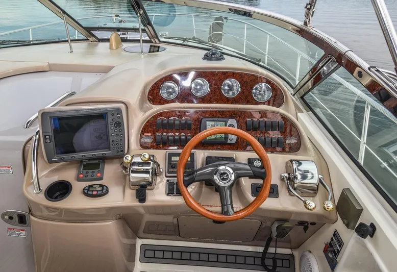  Yacht Photos Pics 2005 Sea Ray 360 Sundancer helm with wood accents and modern navigation equipment.